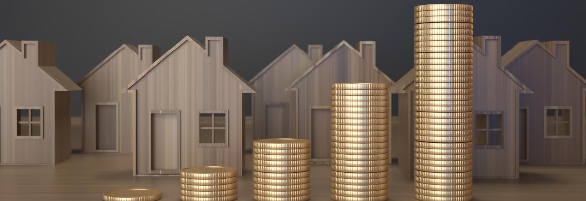 small wooden block houses with stacks of gold coins in front