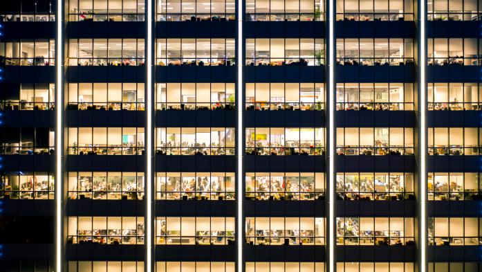 Dozens of lit offices inside a high-rise office building