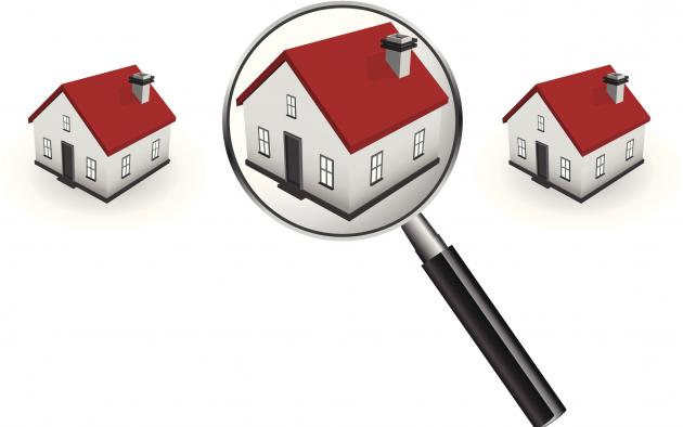 magnifying glass over middle of 3 houses with red roofs
