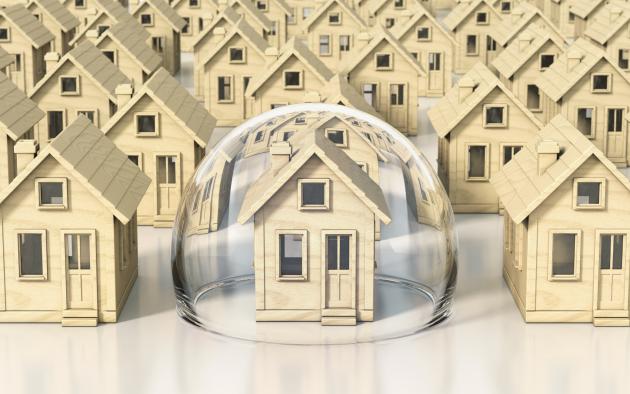 Small models of homes; the center one is covered in a bubble