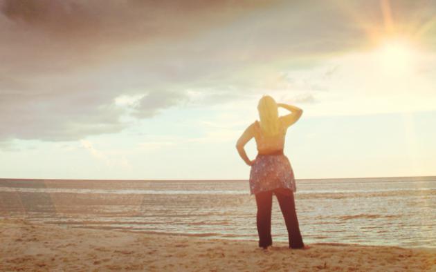 Woman on beach watching storm roll in