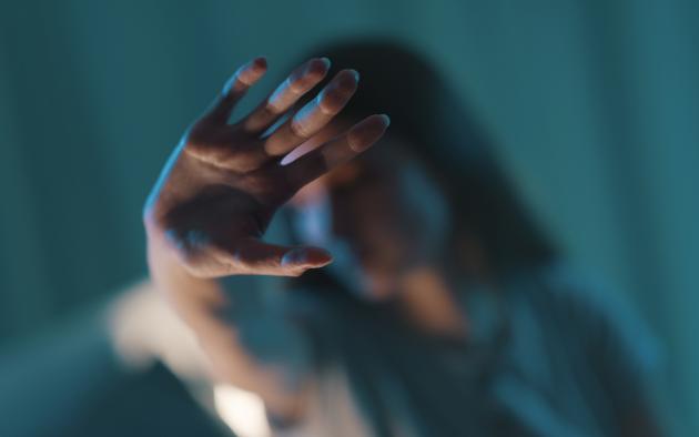 woman in shadow doing stop sign with her hand