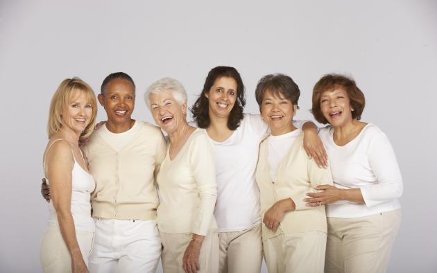 Six happy women of all ages dressed in shades of white