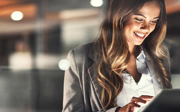 Photo of a business using a tablet and smiling