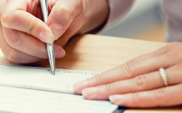 woman's hands writing a check