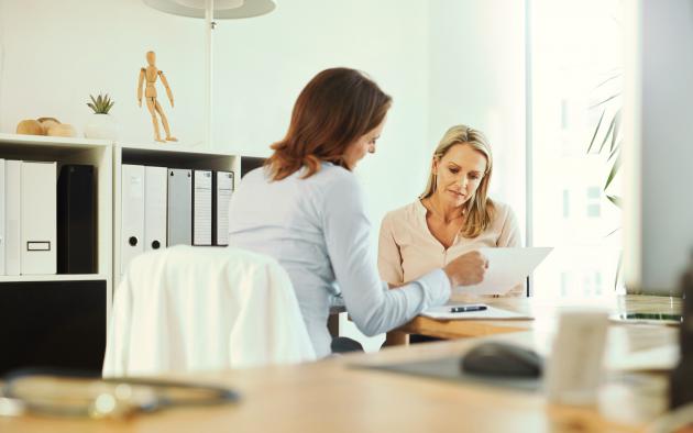 women looking at paperwork filling out forms