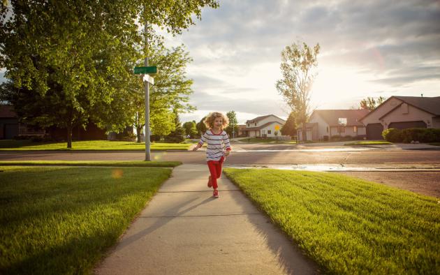 child playing on sidewalk in neighborhood