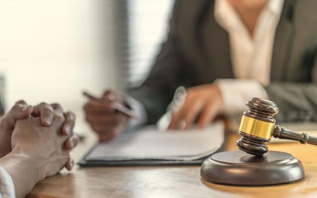 closeup of judge's gavel and closeup and people reviewing paperwork