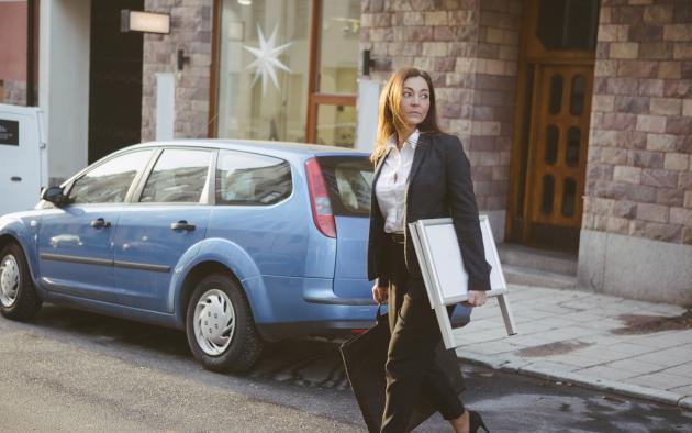 realtor with sign crossing street