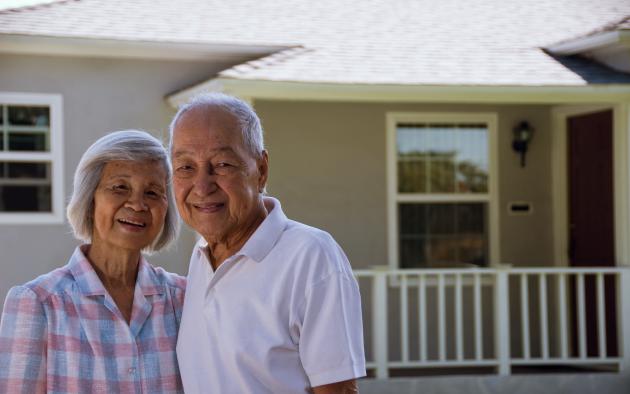 older couple standing outside house