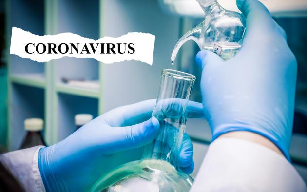 Gloved hands testing liquids for coronavirus
