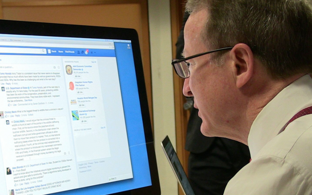 Man at computer looking at Facebook