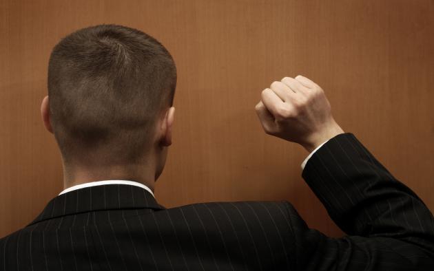 Back of a man's head as he knocks on a door
