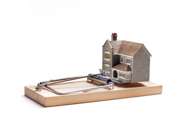 Toy house sitting on a mousetrap