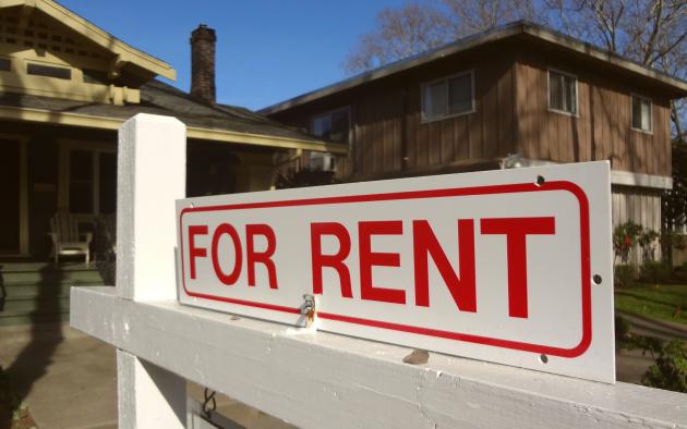 Single-family home with for-rent sign out front