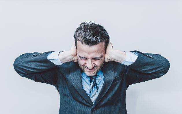 Man holding ears due to noise