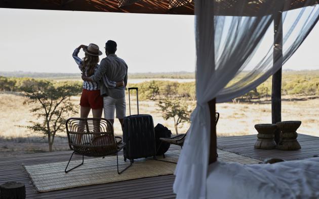 Couple under outdoor canopy with suitcases