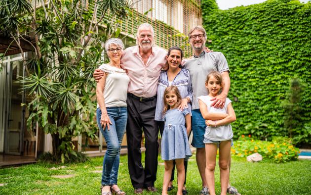 Five people from three generations tand in front of a house