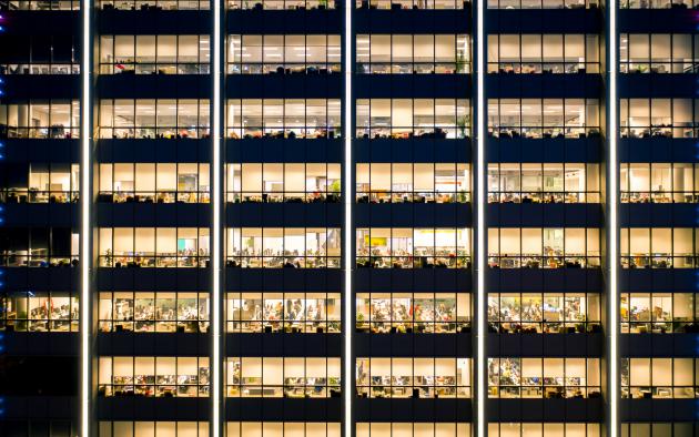 Dozens of lit offices inside a high-rise office building