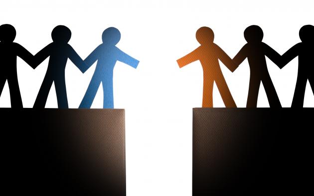 Two groups of people figures approaching each other over a chasm ,ready to shake hands