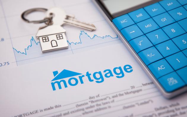 calculator with key on keyring with house on paperwork that says mortgage