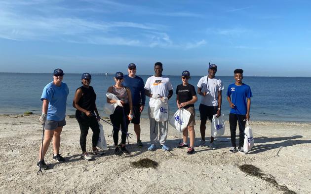 People posing on a beach during a cleanup event