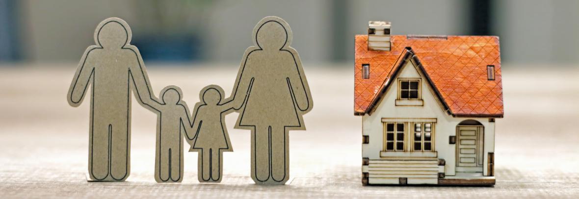Sustainable financial goal for family life concept. Family Paper and house model on the table