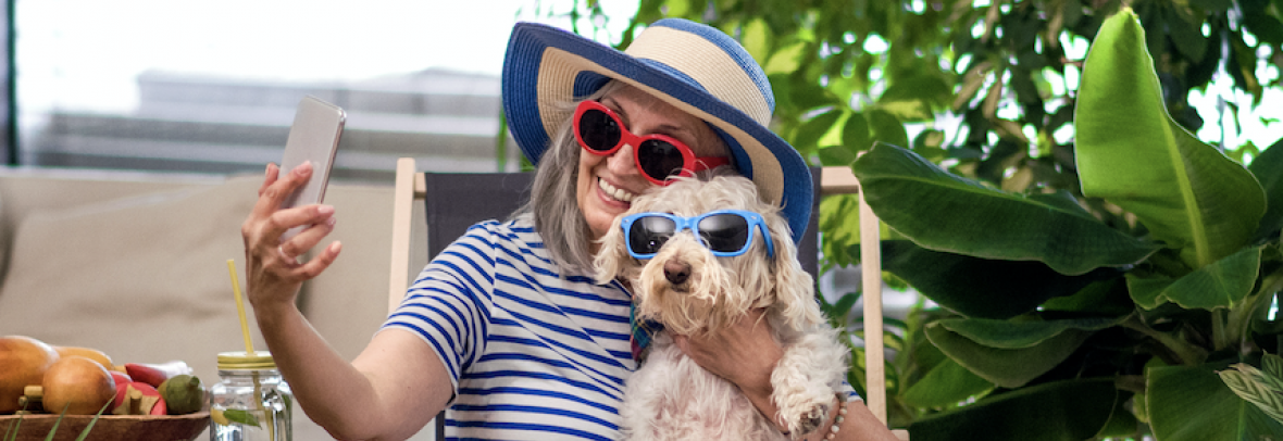 Woman and her dog wear sunglasses while taking a phone selfie