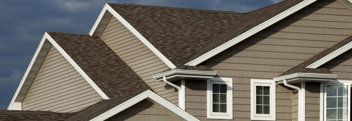 New roof shingles applied to a brown house