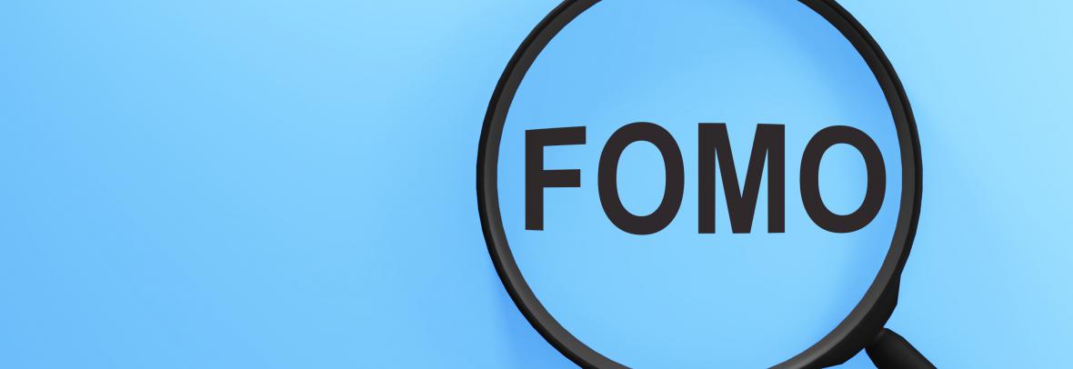 word FOMO on blue background under a magnifying glass