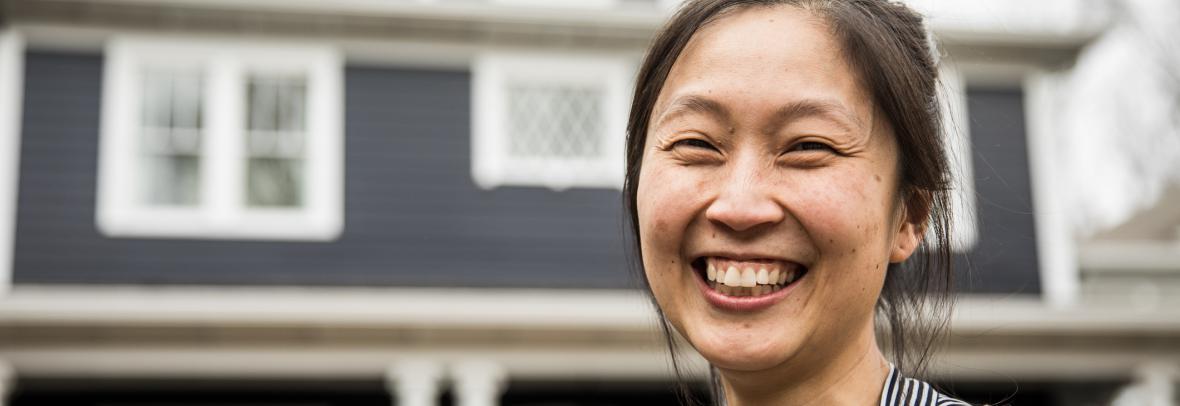 Asian woman in front of home