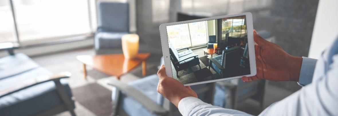 man holding ipad shooting video of a living room