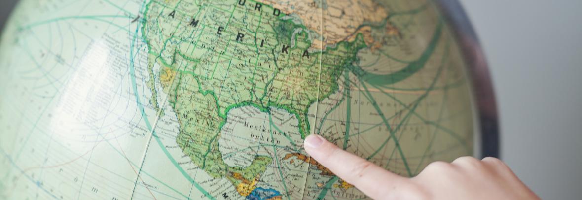 Finger pointing to Florida on a globe of the world