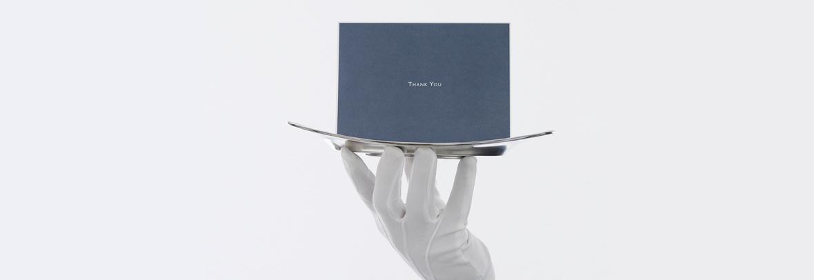 image of a white gloved hand holding a silver platter