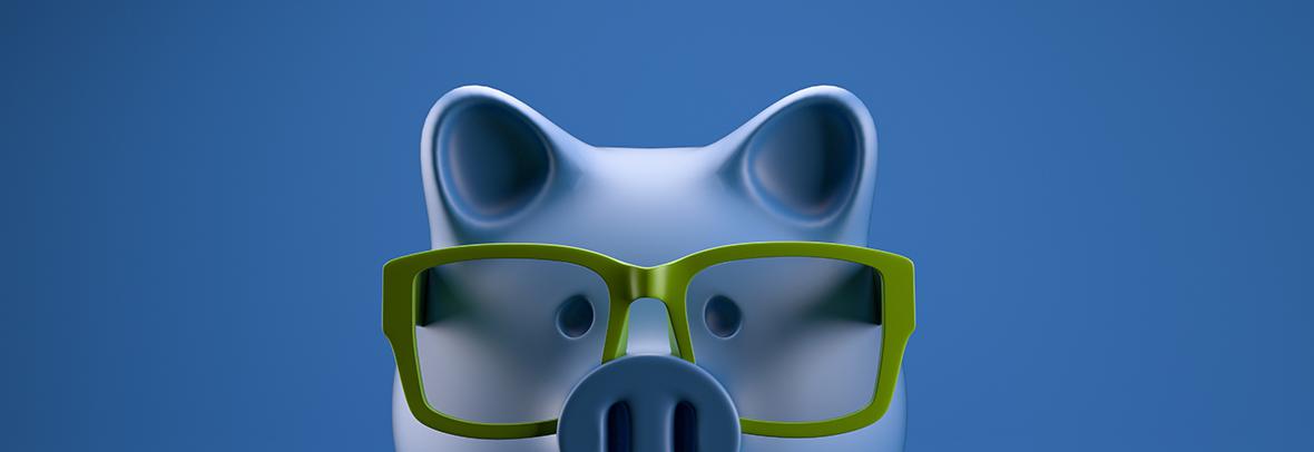 Piggy bank with green glasses on blue background