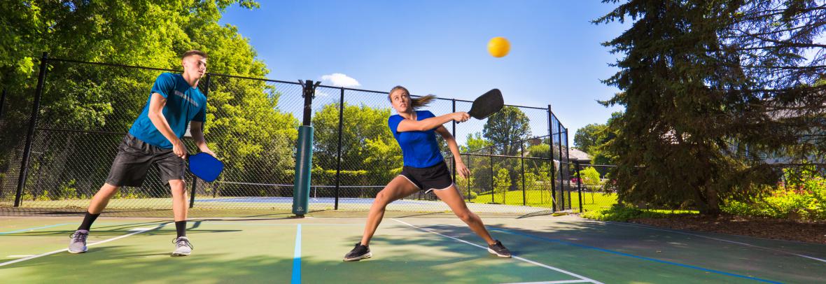 A couple plays on a pickleball court