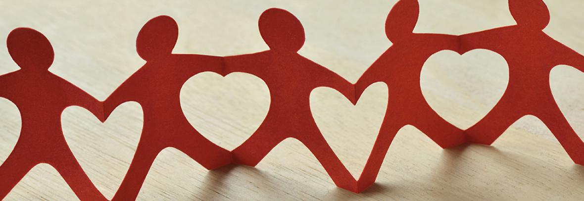 paper cut outs of people holding hands creating heart shapes in between