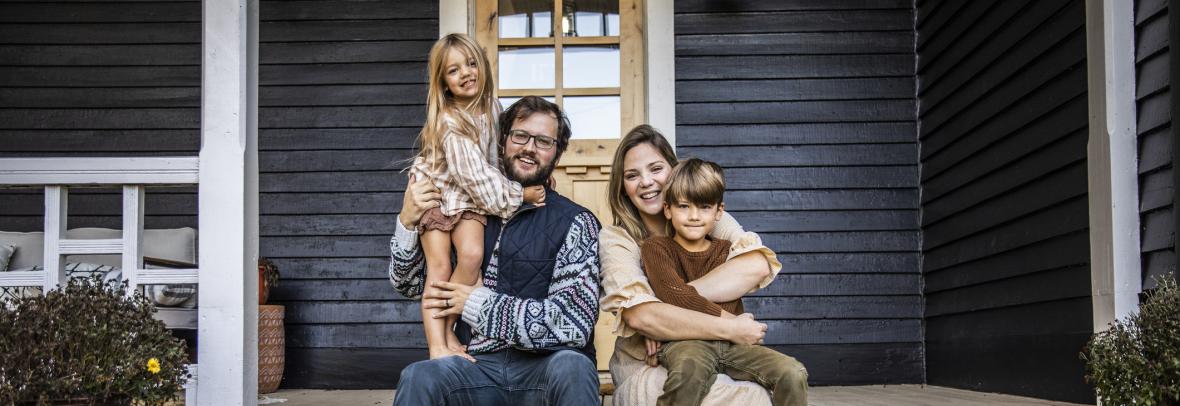 Couple with two young children sitting on front porch