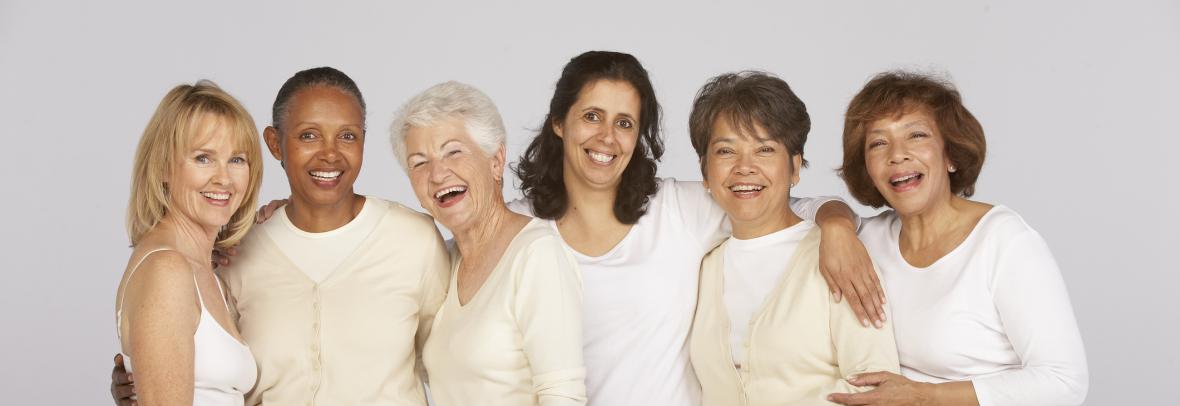 Six happy women of all ages dressed in shades of white