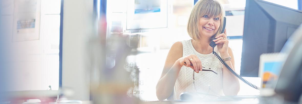 Photo of a female realtor at her desk on the phone