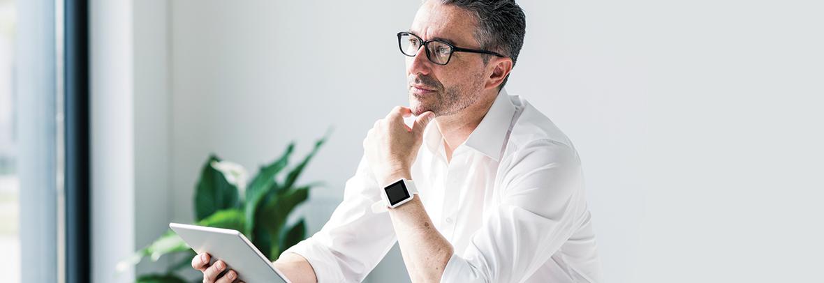 Photo of a business man thinking with tablet in hand