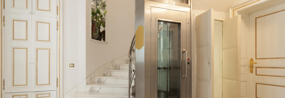 Small elevator beside the staircase of an upscale home