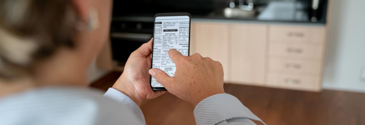woman from back looking at property listing on phone