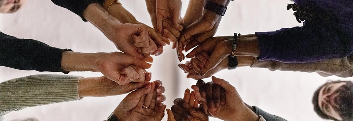 Photo of group of business people grasping hands as a team