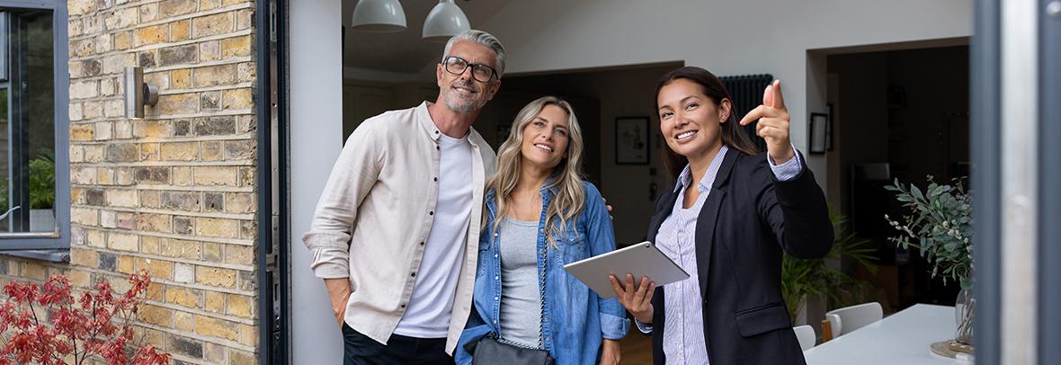 Photo of a realtor showing a property to a couple