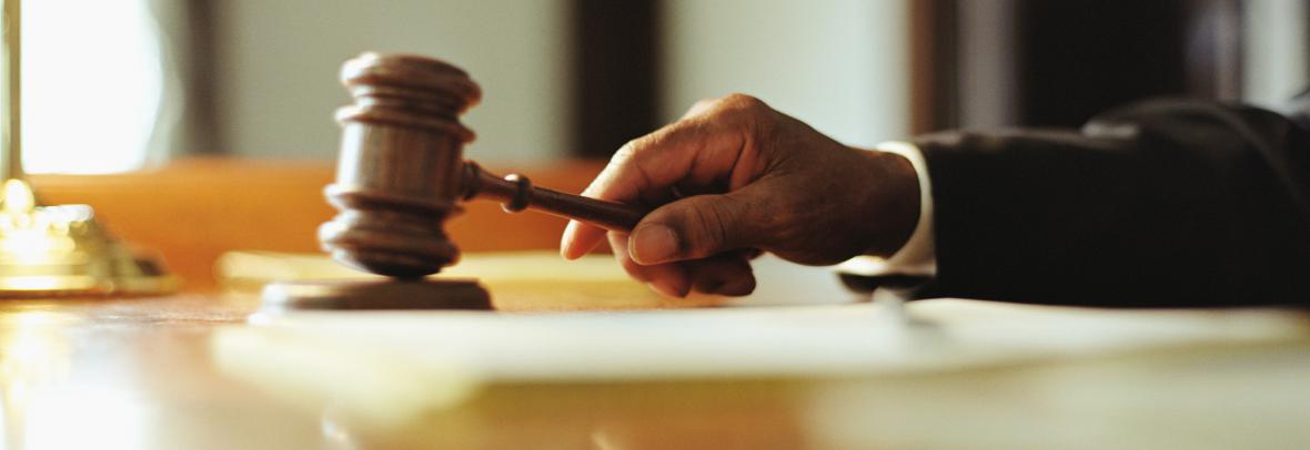 hand with gavel on desk