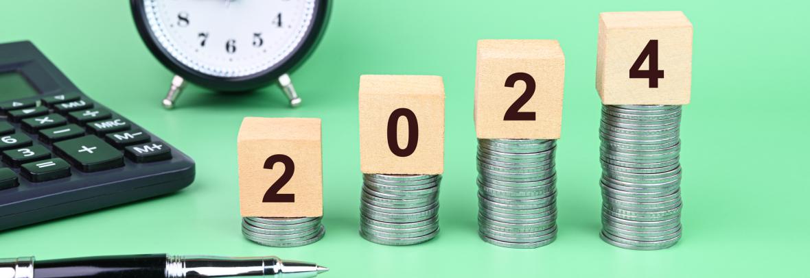 2024 numbers on a progressively higher stack of coins with clock and calculator in background