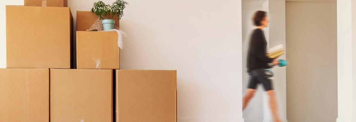 women walking past doorway and moving boxes