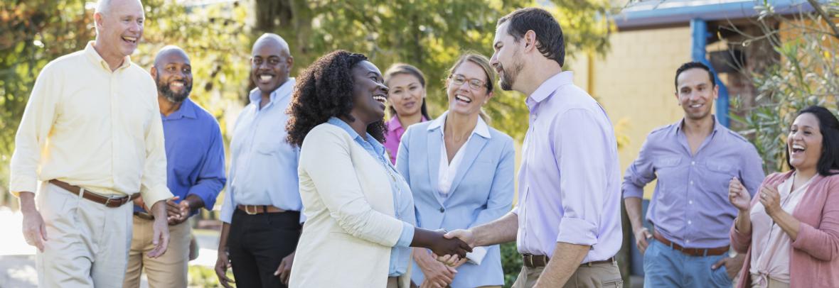 Group of people with man and woman shaking hands