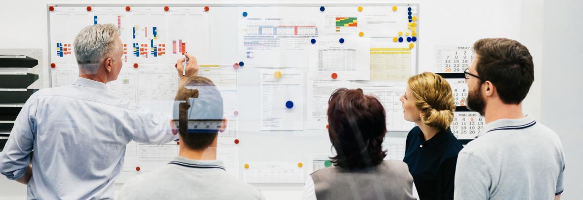 Group of people looking at planning on a board